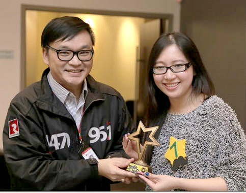 加拿大中文電台粵語節目總監李偉仁（左）頒發獎座給 Radio Idol 冠軍 Winnie 關蘊莉（右），歡迎她加入加拿大中文電台這個大家庭。