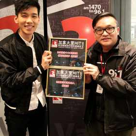 加拿大中文電台節目總監 Alfred（右）為林奕匡（左）頒發加拿大至 Hit 中文歌曲排行榜年度總選的兩項大獎：「全國推崇十大粵語歌曲 - 高山低谷」和「全國推崇唱作人」。