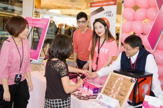 No contribution too small!  A donor (wearing black) buying a pink ribbon pin for $2 from DJs (left to right) Janice Fan, Brian Chiu, Jennie Chen and Brenda Lo.