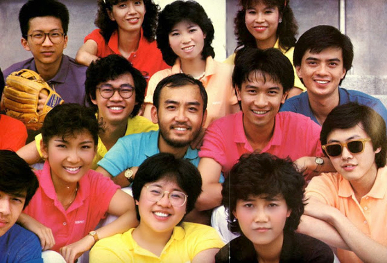 1984 年商台的宣傳照，不但有盧業瑂和黃耀明，還有魏綺清、楊振耀、鍾保羅、陳少寶、邵國華、梁安琪、張麗瑾和露比，還似乎有 t-shirt 贊助呢。	