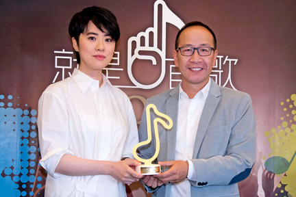 加拿大中文電台集團總裁李方送上音符形狀的紀念座給 Yoyo，預祝 Yoyo 明晚 SQ23 演出成功及於六月底在金曲獎中獲得佳績。