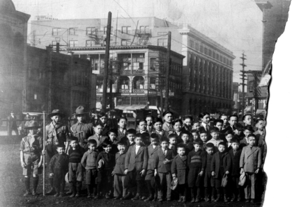 1920 年代華生在現中山公園草坪上合照。圖左最高建築物為當年保皇會大樓（對比下一照片的林西河總堂）。圖中角位建築物為洪門大樓。（City of Vancouver Archives AM1108-S4-: CVA689-65）