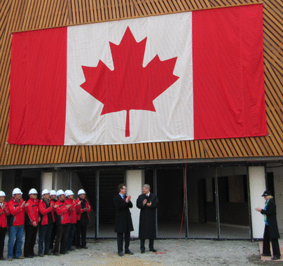 哈珀於加拿大國家館門前拍照留念，圖中國旗是特意為歡迎總理到訪而設