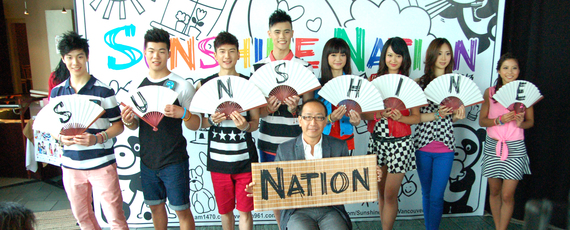 加拿大中文電台總裁李方（前）跟 8位 Sunshine  Boyz & Girlz 手舉寫有英文字的中式紙扇及竹匾，配合大會主題「中國風」