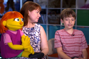 製作《芝麻街》木偶的 Stacy Gordon，有一名有自閉症的兒子，在她得知《芝麻街》將加入自閉症孩子的角色後，主動提出由她來設計和演繹 Julia 的木偶，圖為她和兒子接受《60 Minutes》的訪問，講述兒童節目加入自閉症角色的意義。