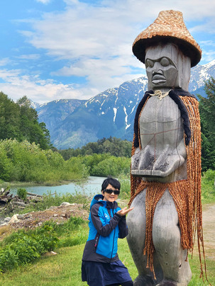 Bella Coola 河旁手奉燭魚的草衣木像，是用來紀念魚油對當地民生的貢獻。