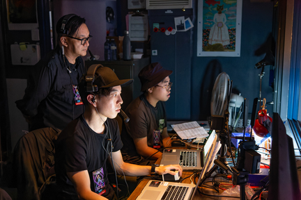 大會製作總監加拿大中文電台台長李偉仁（左），一眼關七台上的表演，並發號施令燈光、音響、背景動畫和歌詞字幕的配合，責任重大。